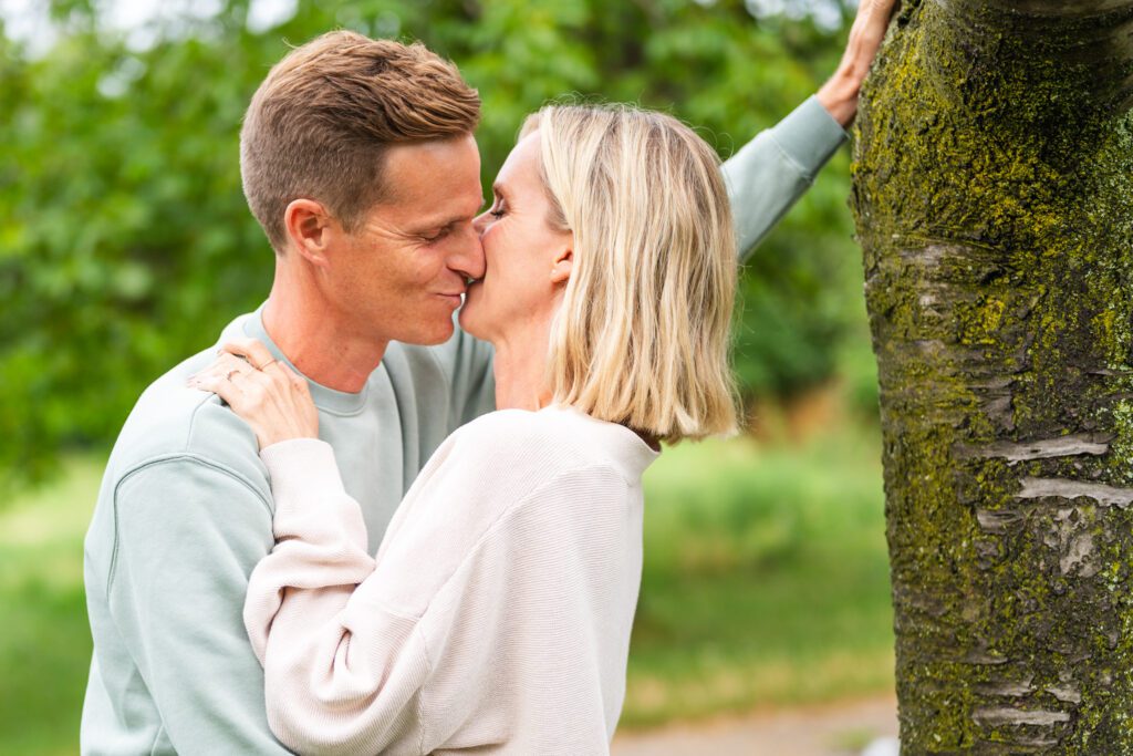 Pärchen knutscht an einem Baum angelehnt