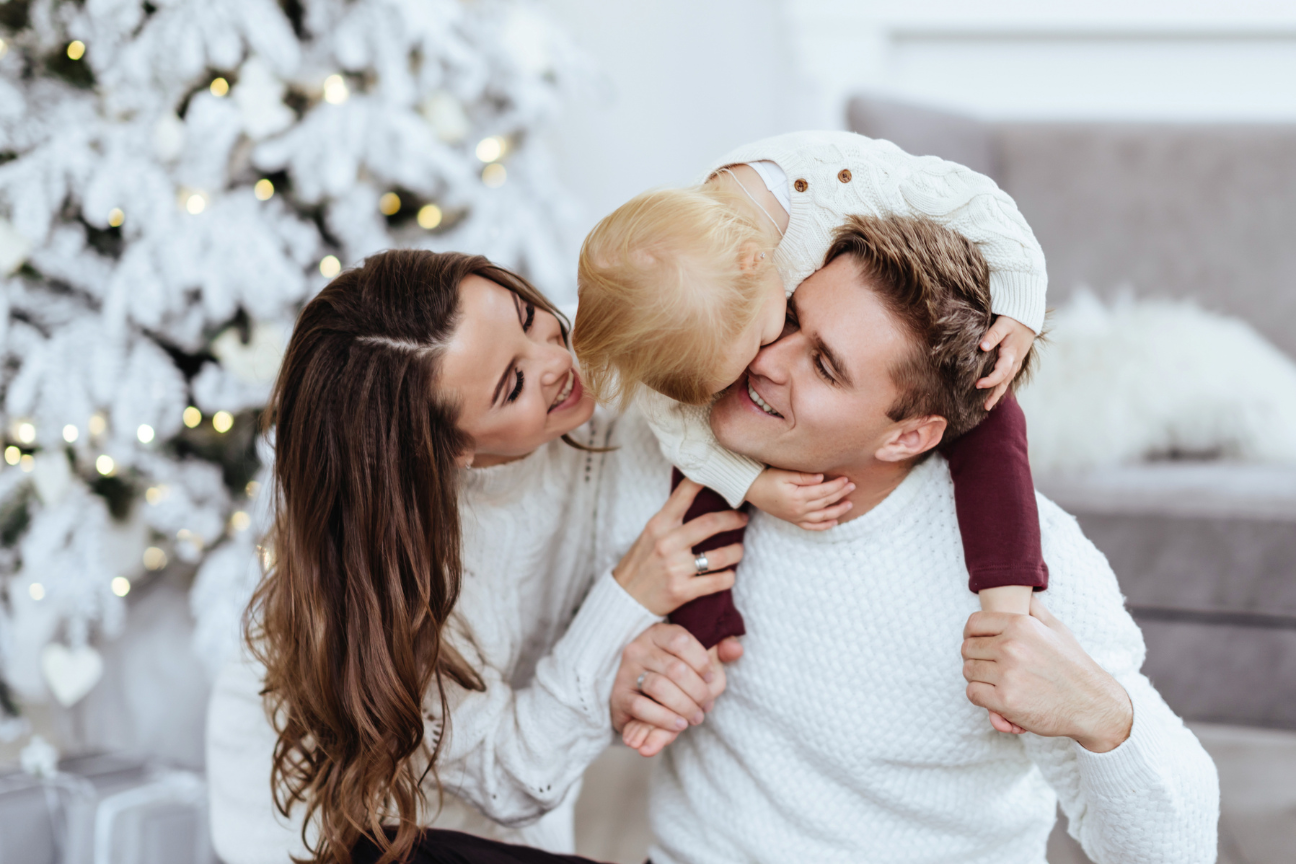 Weihnachten mit der Family. Familienfoto vor dem Weihnachtsbaum.